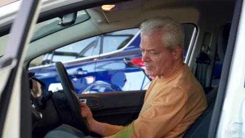 Senior man exploring the luxurious interior of a car Stock Footage 311983898