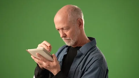 Senior Man Expresses Emotion While Posing in Front of Solid Green Background Stock Footage 305569823