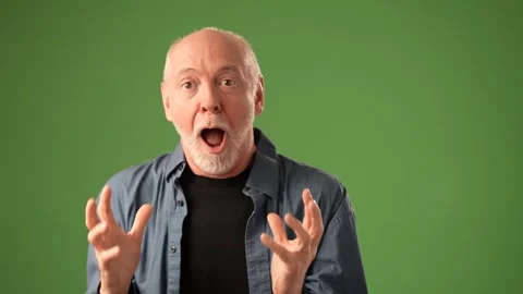Senior Man Expressing Emotion With Hands Clasped Under a Green Background Stock Footage 305553647