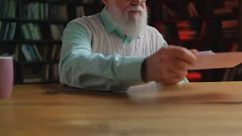 Senior man in eyeglasses checking postal mail, shocked by amount of unpaid bills Stock Footage 314056354