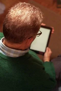 Senior man in eyeglasses using digital tablet. Stock Photos