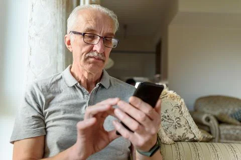 Senior man in eyeglasses using mobile phone Stock Photos