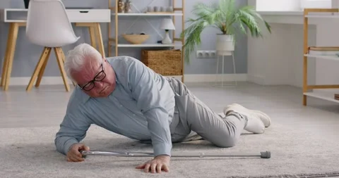 Senior man falling down and lying on the floor with walking stick at home trying Stock Footage 307919559