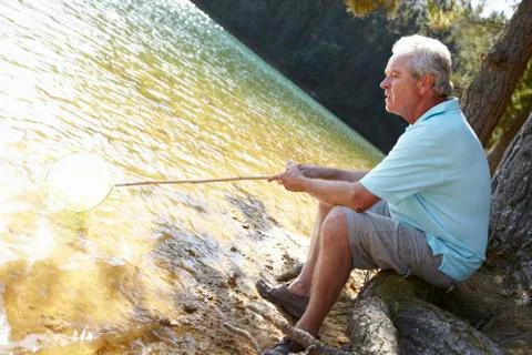 Senior man fishing at lake Stock Photos