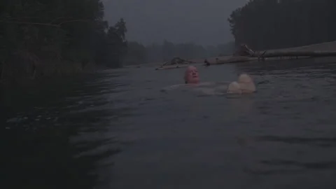 Senior man floating on his back down a river Stock Footage 331659997