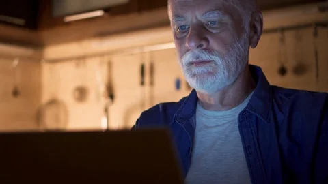Senior man freelancer using laptop at night from home office. Overworked Stock Footage 95391582