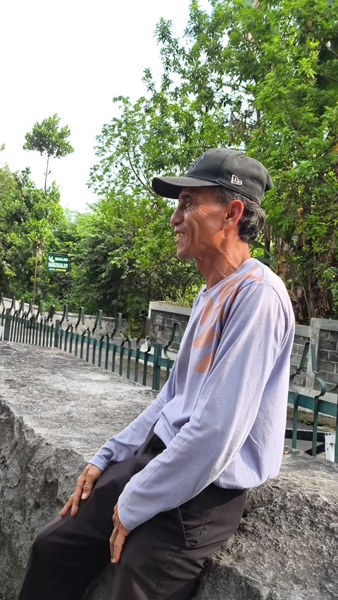 Senior man gestures animatedly beside a green fence Stock-Footage 345204699