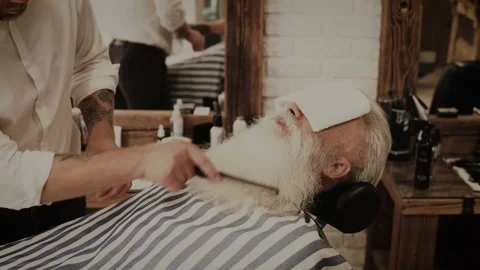 Senior man getting styling and trimming of his beard in the barbershop Stock-Footage 233626687