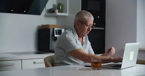Senior man with glasses using laptop computer for shopping online and paying Stock Footage 146410127