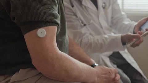 Senior Man with Glucose Sensor Checking Data with Doctor Stock Footage 339611978
