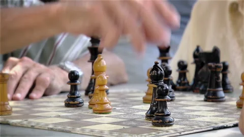 Senior Man Hand Crowning A Black Pawn During Chess Game In The Park - 4K Vídeo Stock 334136897