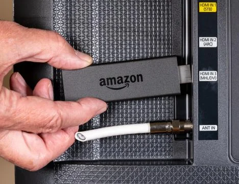 Senior man hand inserting Amazon Fire TV device Stock Photos