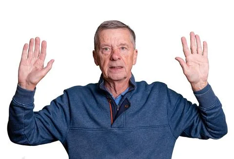 Senior man with hands raised in surrender isolated against white Foto stock