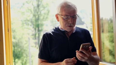 Senior man has problems with his vision while read something on his smartphone Stock Footage 80888740
