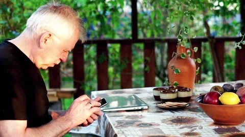 Senior man has problems with his vision while trying to read something on phone Stock Footage 125990934