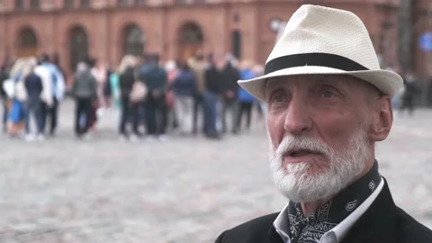 Senior man in hat with beard talks on blurred background Stock Footage 136418887