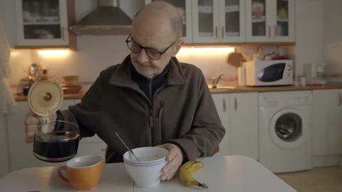 Senior Man Having Breakfast Alone in a Kitchen Setting Stock Footage 307739723