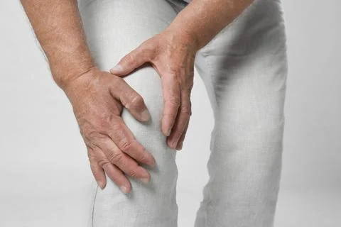Senior man having knee problems on grey background, closeup Stock Photos