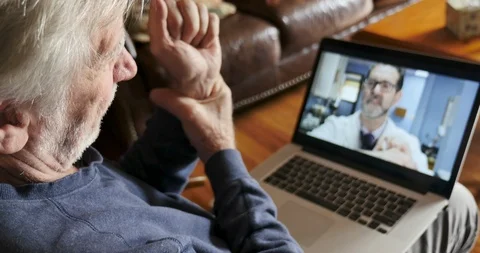 Senior man having a virtual exam during a telemedicine appointment Stock Footage