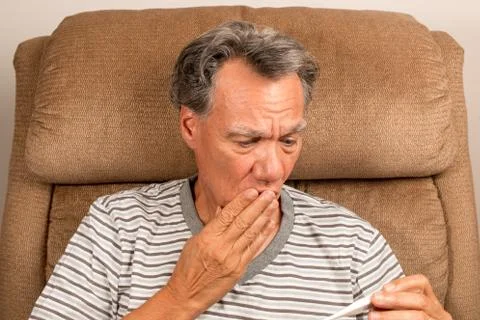 Senior Man at home checking his Temperature Stock Photos