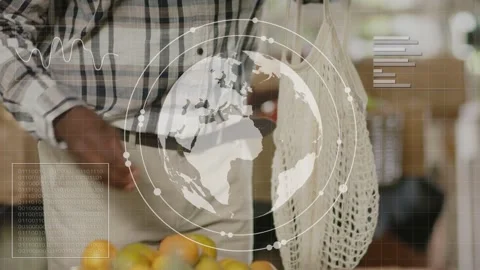 Senior man hovering over grocery starting globe and charts while picking oranges Stock Footage 335480844