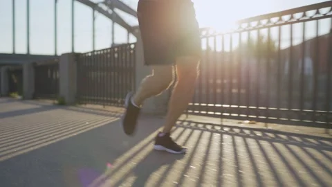 Senior man jogging on bridge in sunlight Video stock 135562190