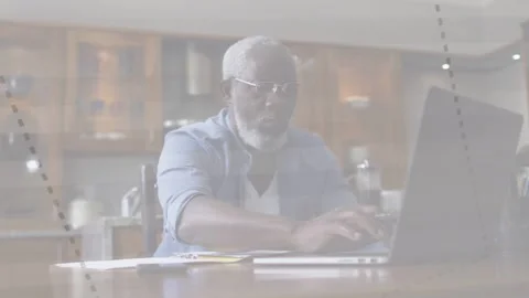 Senior man at kitchen typing on laptop adding dotted overlays checking business Stock Footage 333278030