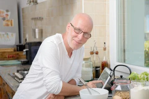 Senior man in kitchen using  tablet Foto stock
