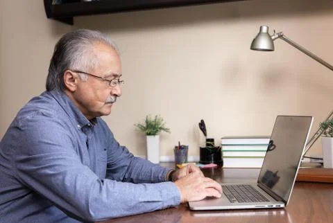 Senior man learn to use computer. Old man in glass and blue shirt using a lap Foto stock