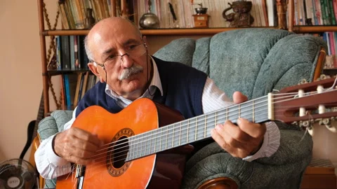 Senior man learning to play guitar at home Stock Footage 131847454
