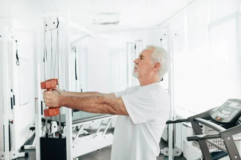 Senior man lifting weights at an exercise class. healthy lifestyle old people Stock Photos