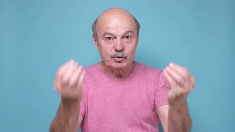 Senior man looking angry showing italian gesture Stock Footage 136437964