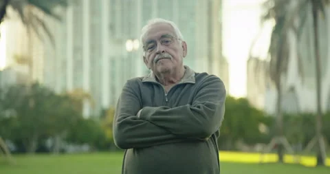 Senior man looking at camera and crossing his arms at park Stock Footage 234533355