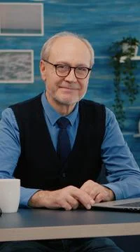 Senior man looking at camera smiling sitting in workplace at desk Foto stock