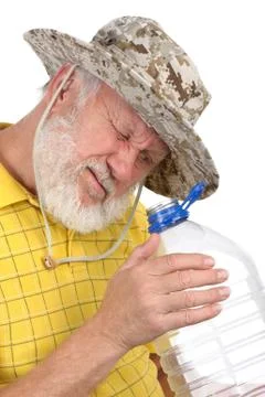 Senior man looking into empty bottle Stock Photos