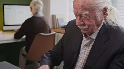Senior Man Looking at Laptop Screen in Computer Class for Seniors Stock Footage 333704021
