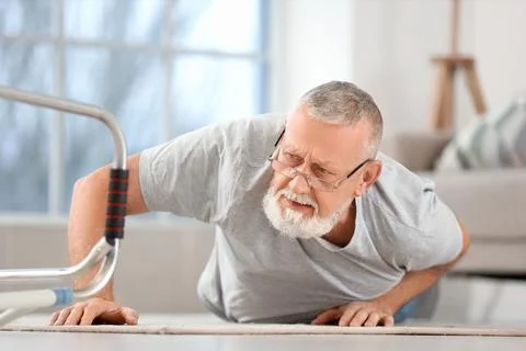 Senior man lying after fall with walker at home Stock Photos