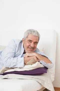 A senior man lying on a couch Stock Photos