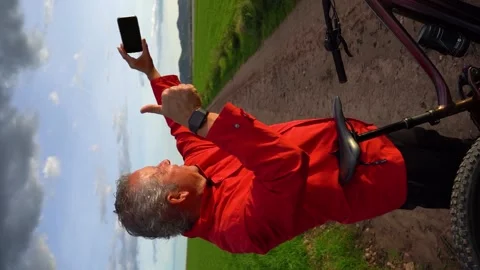 Senior man makes video call with mobile while riding an electric bike throu.. Stock Footage 225712261