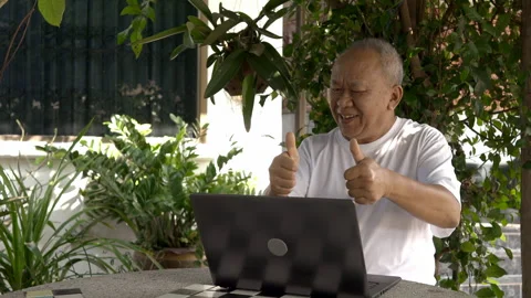 Senior man making a video call in the garden Stock Footage 253146874
