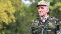 Senior man in military uniform shoots a revolver HD Footage