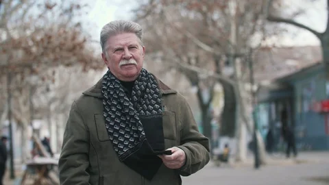 Senior man with a mustache in jacket walking in a street in autumn in slow Stock-Footage 104113294