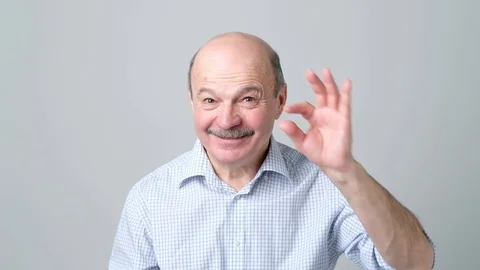 Senior man with mustache showing something small with figers. Stock Footage 102802355