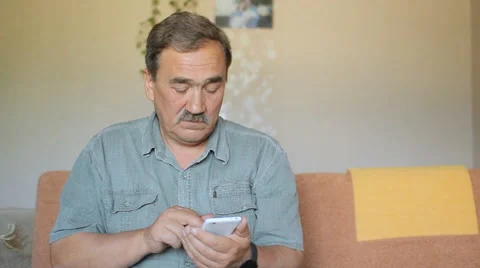Senior man with a mustache touching the mobile phone. He wrote in the social Stock Footage 65375928