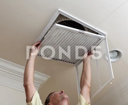 Senior man opening air conditioning filter in ceiling Stock Photos