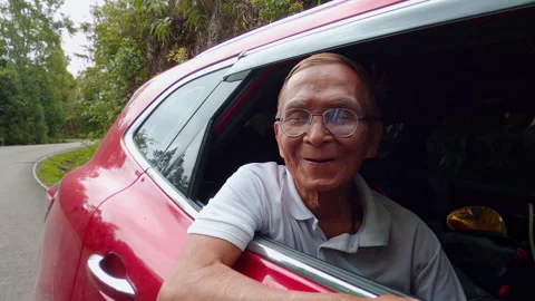 Senior man opens the window to see beautiful view during road trip with family. Stock Footage 156080887