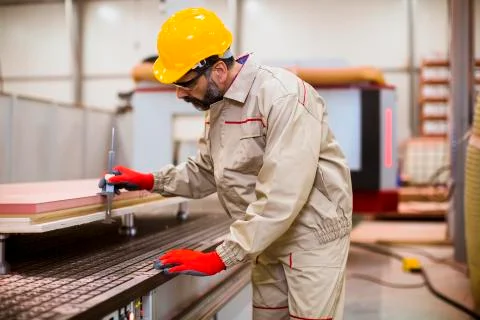 Senior man operating machine units in modern factory standing by control pane Stock Photos