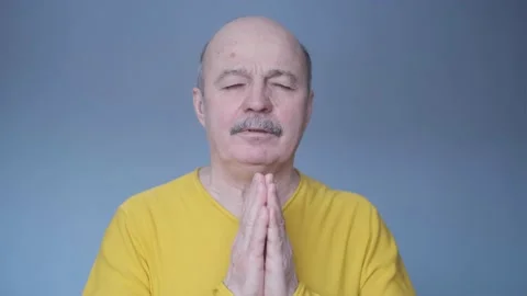 Senior man over isolated blue background keeps palm together. Stock Footage 169729592