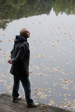 Senior man overlooking pond Stock Photos