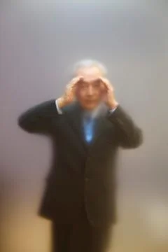 Senior man peering through screen Stock Photos
